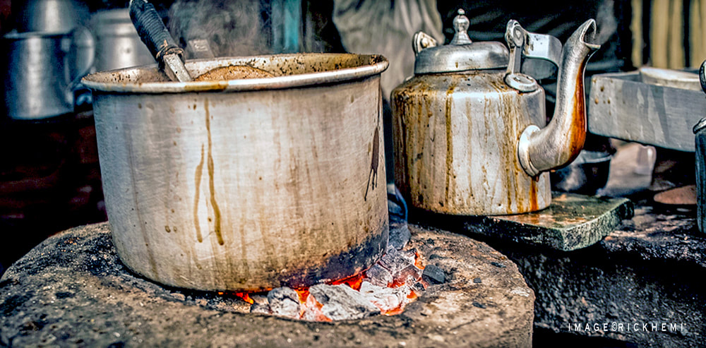 solo overland travel Asia, side street coal stove chai, image by Rick Hemi